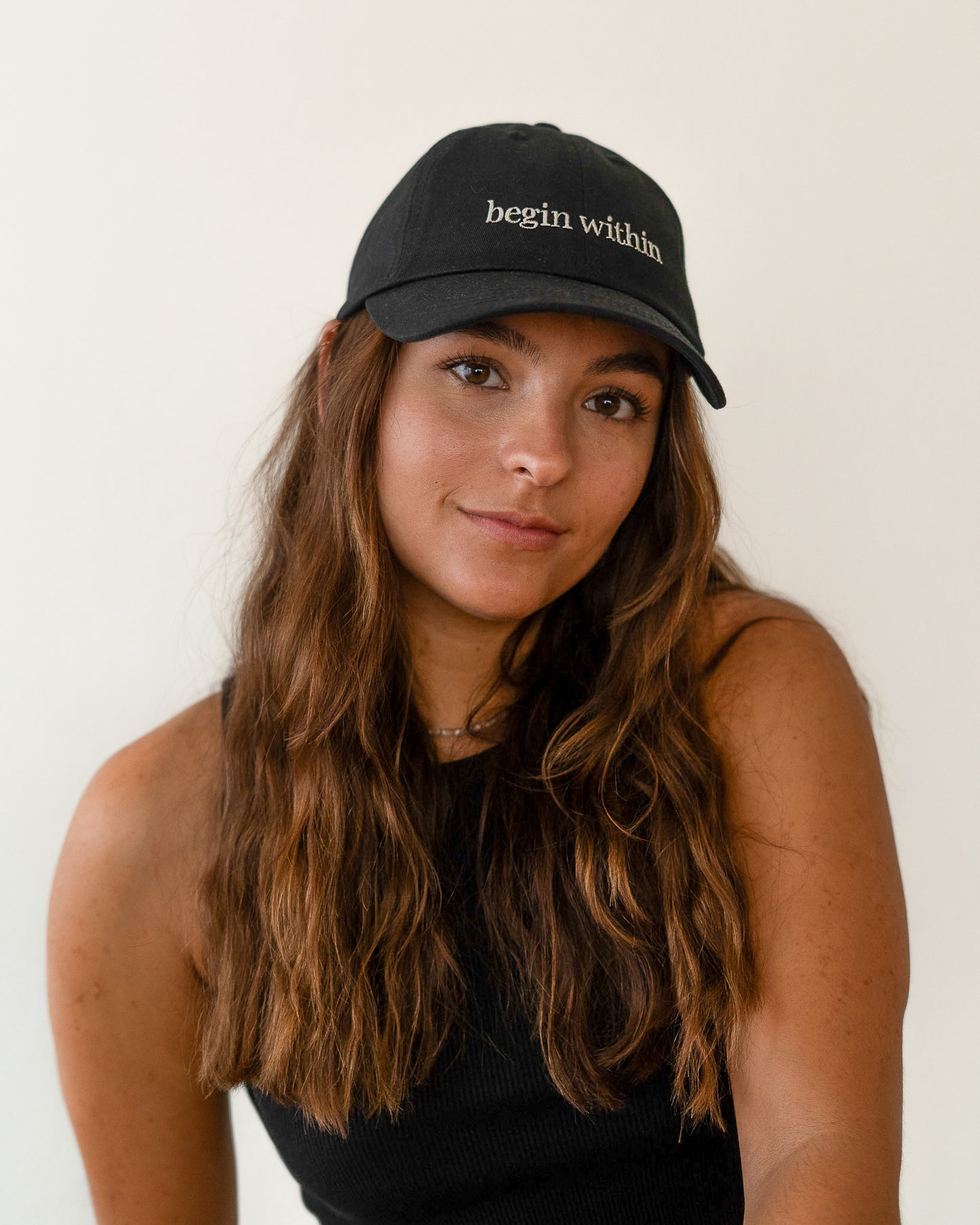 AVE dad cap in black, worn by a woman, begin within embroidery
