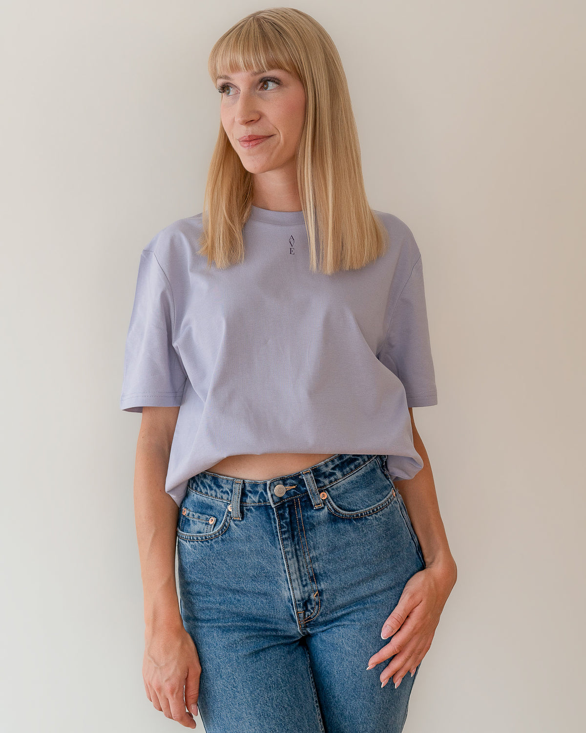 TESSERA t-shirt in lavender, worn by a woman, tucked in, AVE lettering at the neckline