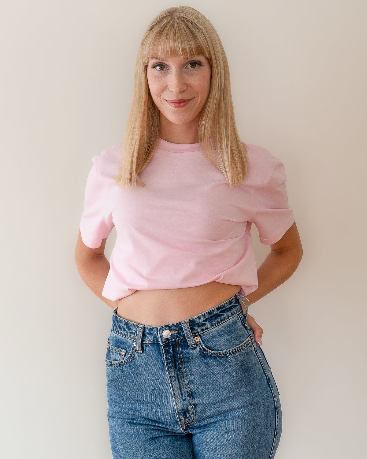 TESSERA t-shirt in pink, worn by a woman, tucked in, AVE lettering at the neckline