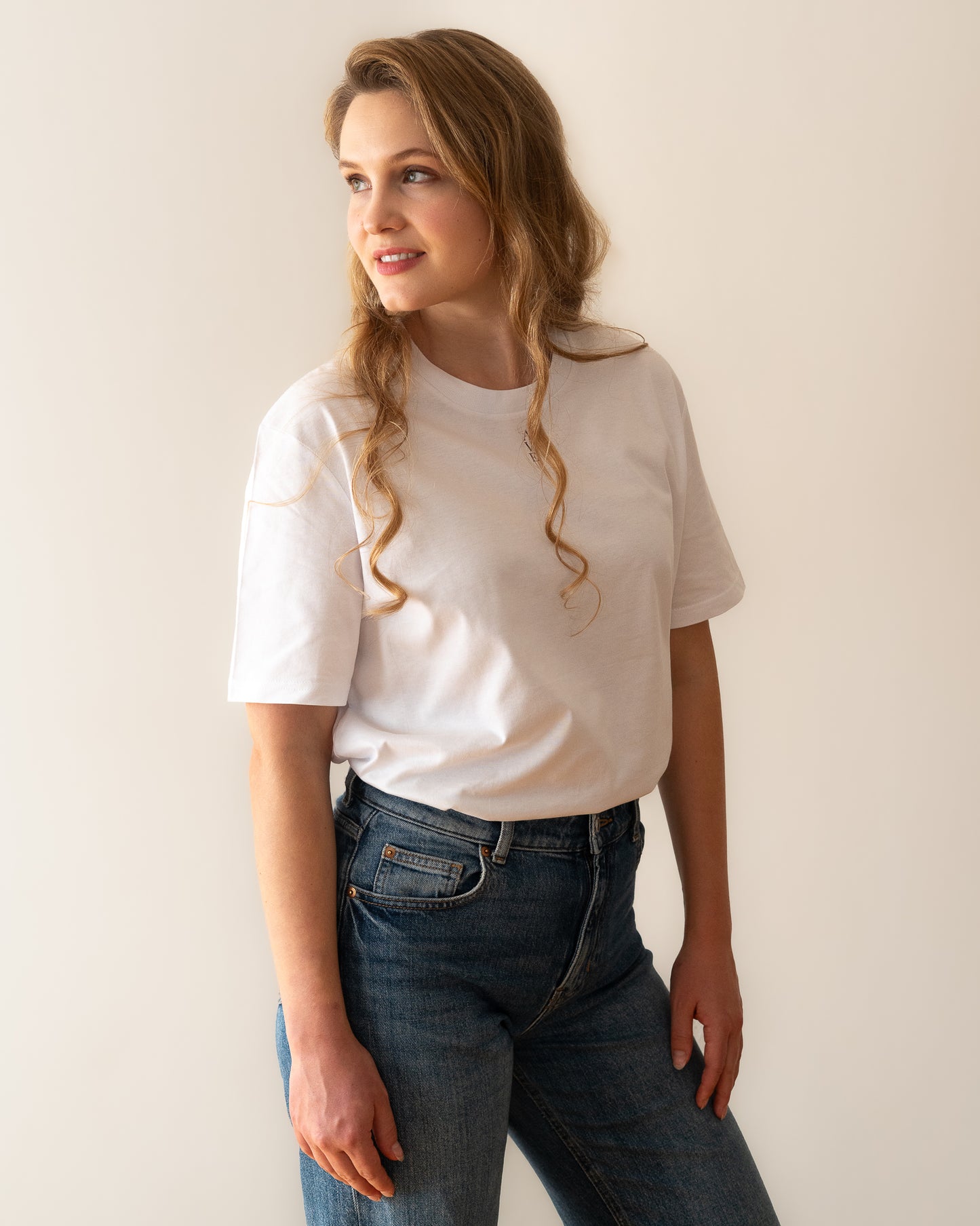 TESSERA t-shirt in white, worn by a woman, tucked in, AVE lettering at the neckline