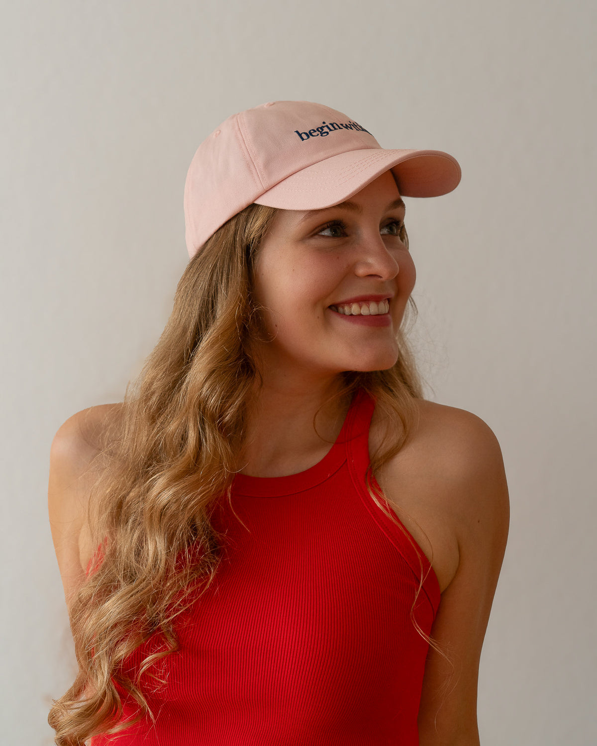 AVE dad cap in pink, worn by a woman, side view