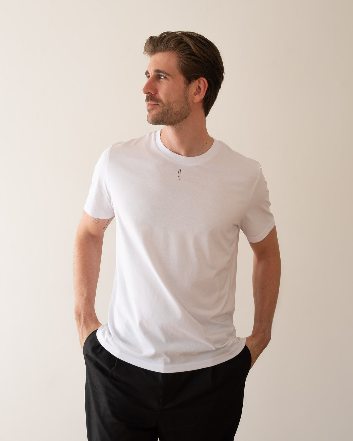 TESSERA t-shirt in white, worn by a man, worn loose, AVE lettering at the neckline