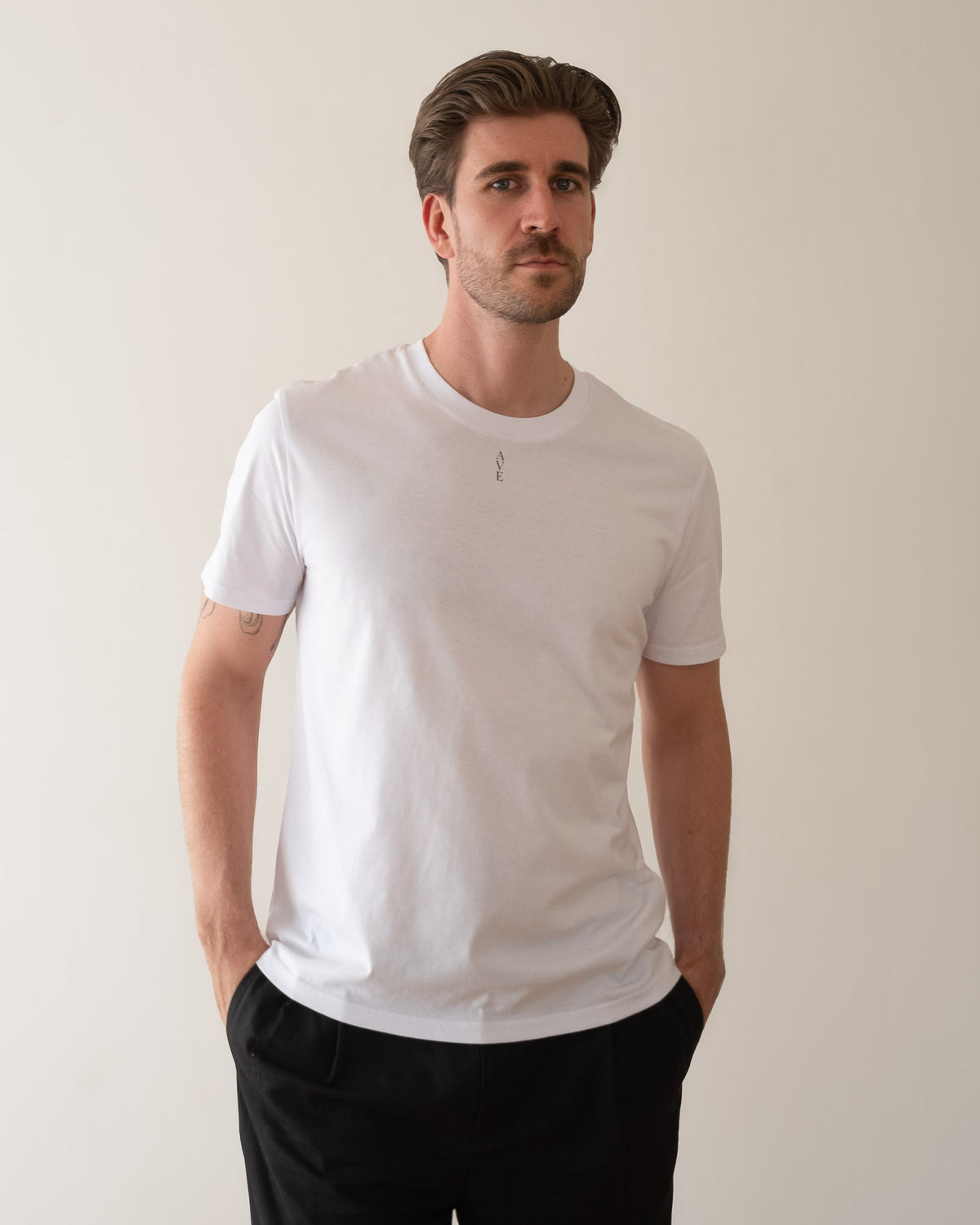 TESSERA t-shirt in white, worn by a man, worn loose, AVE lettering at the neckline